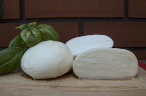 Mozzarella fresca su un piatto, con verdure e pane, simbolo di una dieta equilibrata.