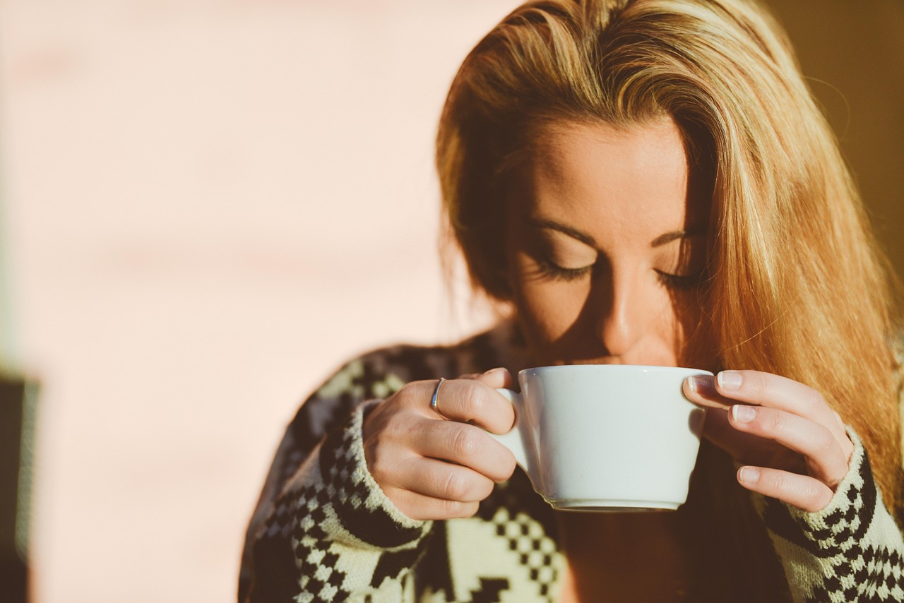 Tazza di caffè accanto a un sole stilizzato, simbolo della vitamina D.