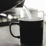 Tazza di acqua calda su un tavolo, simbolo di benessere prima di dormire.