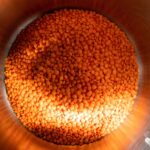Lenticchie cotte in una pentola con spezie e aromi, pronte per essere servite.