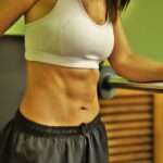 Donna che pratica esercizi per ridurre il grasso addominale in un ambiente fitness.