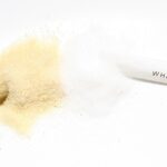 Confronto tra zucchero bianco e zucchero integrale su sfondo neutro.