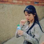 Immagine di una persona che beve acqua per combattere la bocca secca durante l'estate.