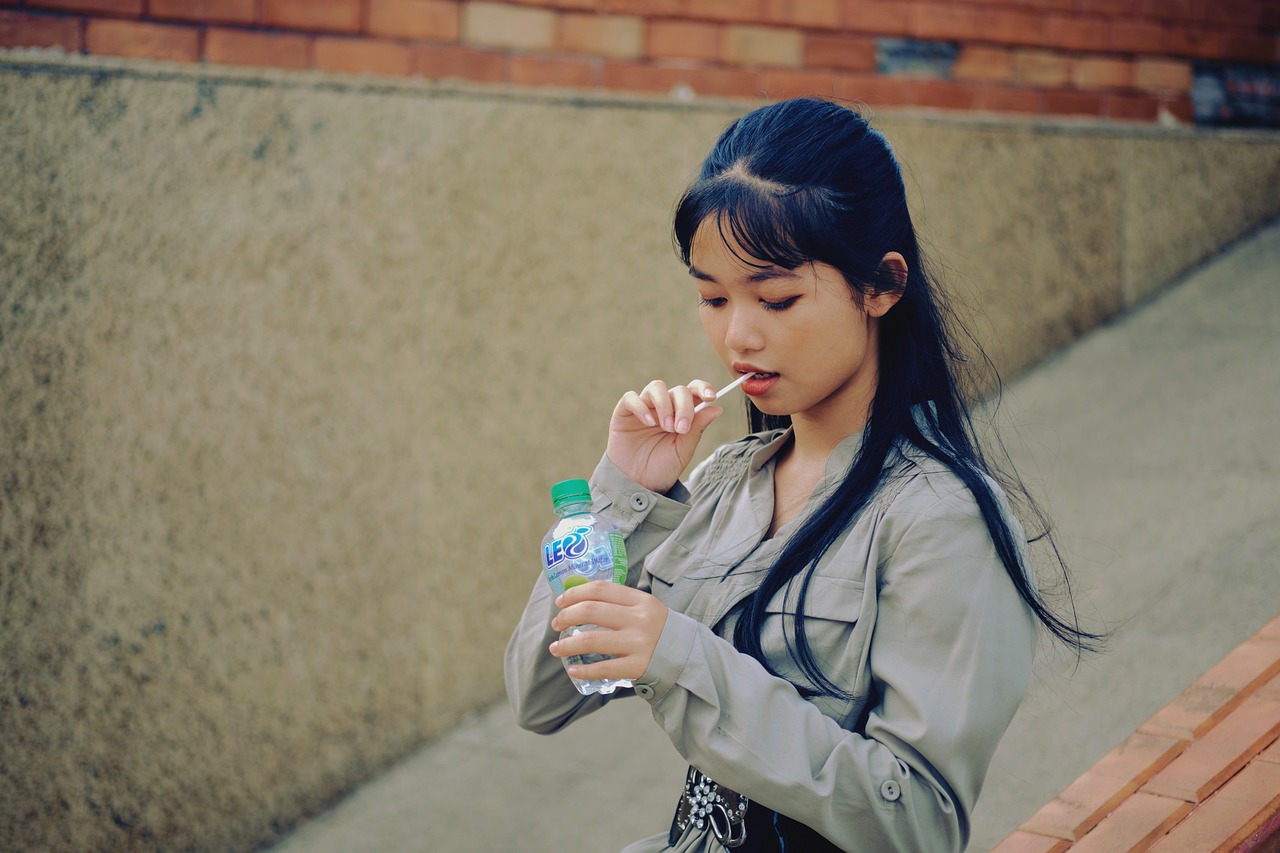 Immagine di una persona che beve acqua per combattere la bocca secca durante l'estate.