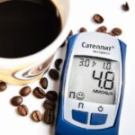 Tazza di caffè fumante con chicchi di caffè e un grafico sul colesterolo.