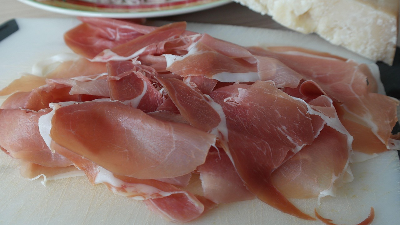 Immagine di un pacchetto di prosciutto crudo con un'etichetta rossa e avviso di salute.
